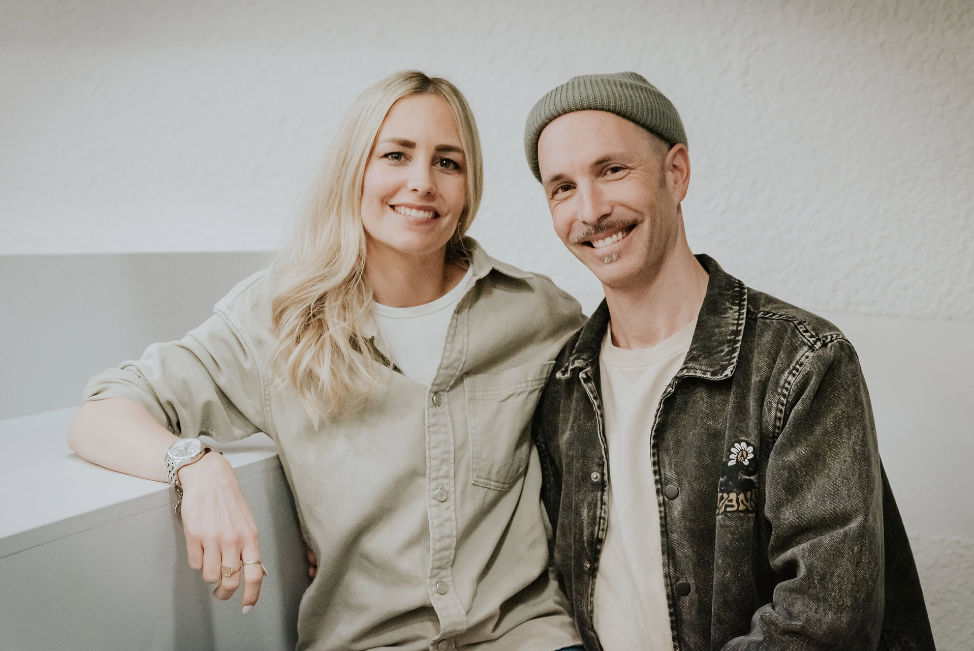 Ein Mann und eine Frau stehen nebeneinander und lächeln in die Kamera.