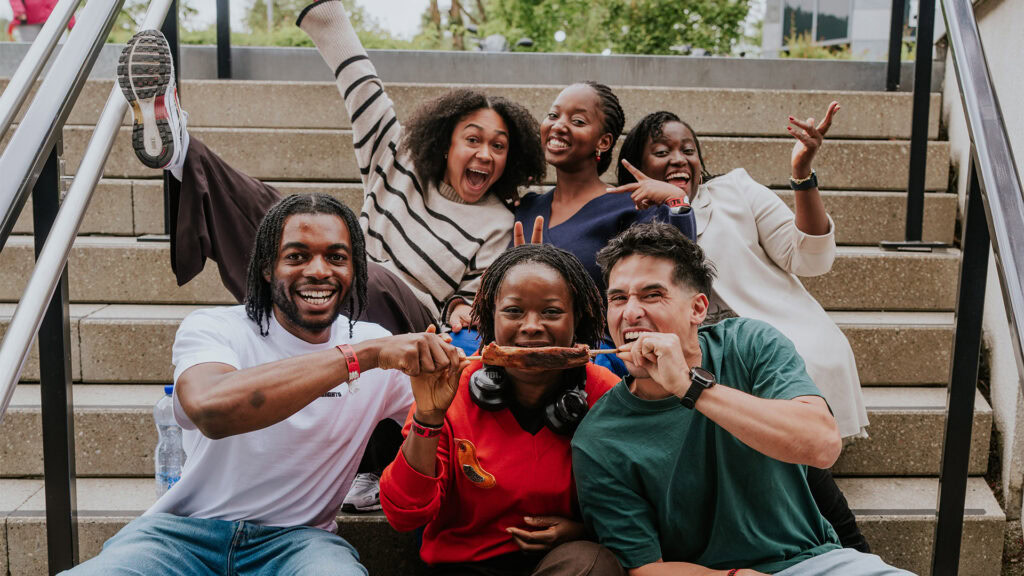 Five people sitting on stairs, laughing and having fun.