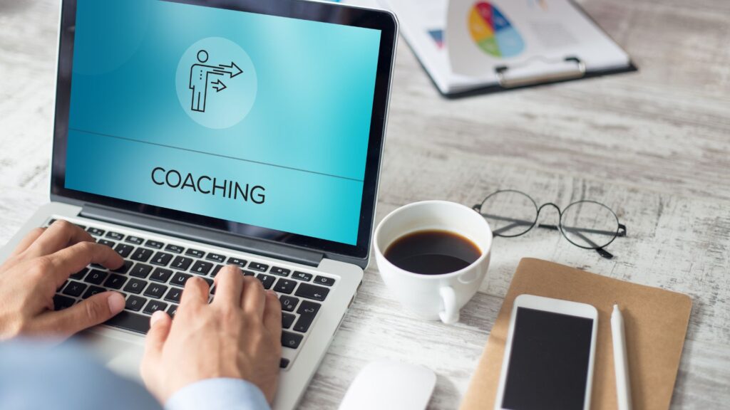 Laptop zeigt eine Coaching-Seite mit einer Figur und Pfeil.