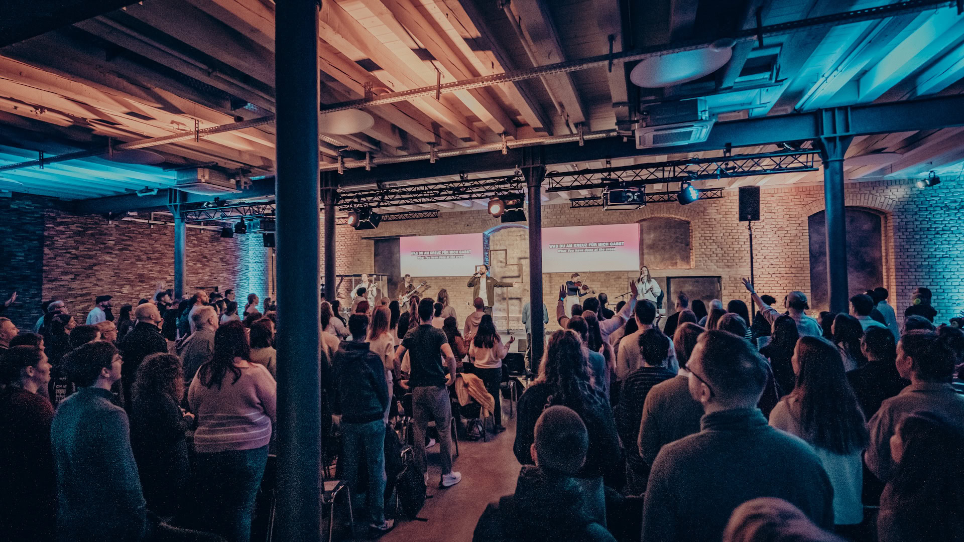 Einblick in einen lebendigen Gottesdienst bei ICF Mannheim mit einer Band auf der Bühne, inspirierende Predigt, zahlreiche Besucher, moderne Kirche, Gemeinschaft im Glauben, Worship, christliche Musik, geistliches Treffen, evangelischer Gottesdienst, Kirche in Mannheim.