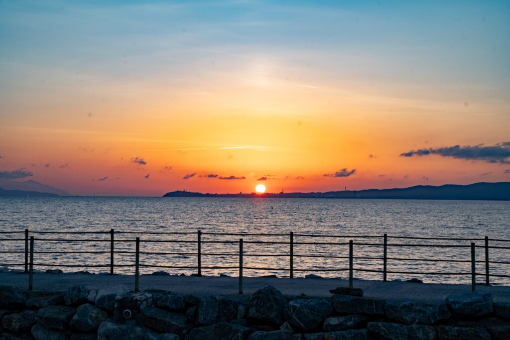 Sonnenuntergang über dem See mit Horizont und Wolken.
