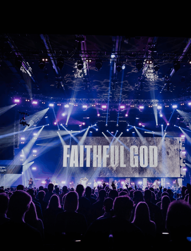 High-energy worship concert at ICF Zürich with vibrant stage lighting and a large audience, featuring a dynamic atmosphere and inspiring Christian music performance.