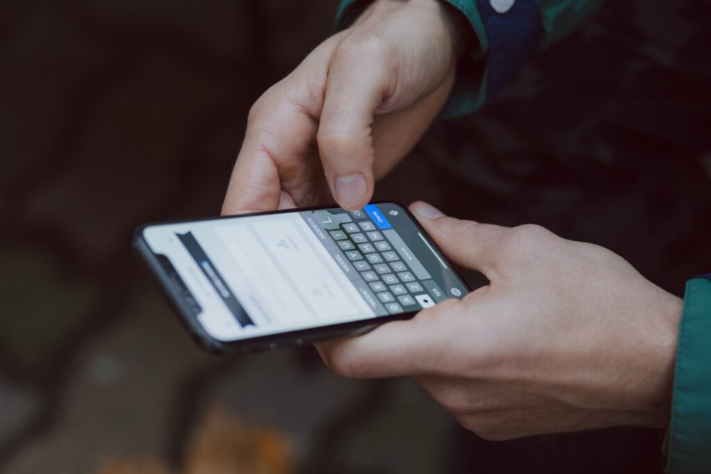 Person hält Smartphone mit Textnachricht auf dem Bildschirm.